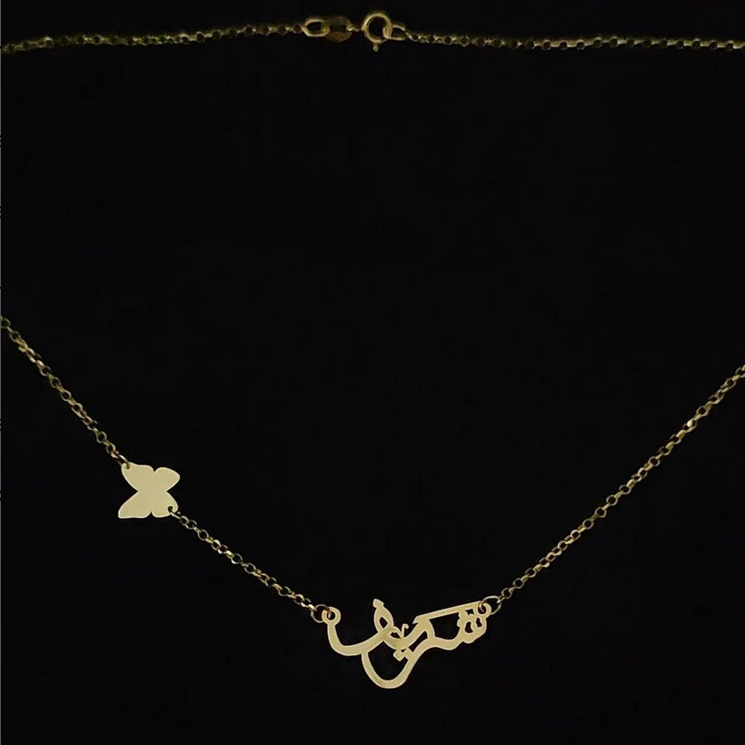 Collier prénom en arabe avec écriture arabique et papillon 🦋 latéral avec une chaine chopard épaisse en Or 18 carats.